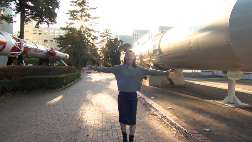 JAXA相模原キャンパスの屋外ロケット展示場所にいる瞳ゆゆリポーター