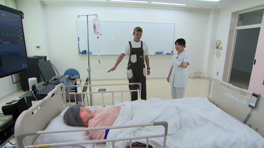 県立よこはま看護専門学校にて、シミュレーションを用いた看護体験をするマーティンリポーターと飛澤海月先生