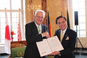 覚書を手に握手するクレッチュマン首相と黒岩知事（2014年11月）