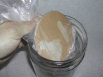 写真：段ボール紙を丸く切り、防水のためポリエチレン袋に入れれば、手軽な押しブタになる