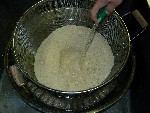 写真：ザルに米を入れ、ざるの外側にザルよりも大きい容器を受けにして水を入れる