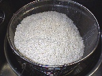 写真：吸水した米をザルに上げる