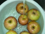 写真：リンゴを水で洗う