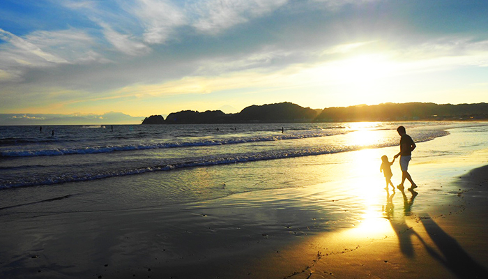 Walking along the beach while watching sunset in the early evening.1