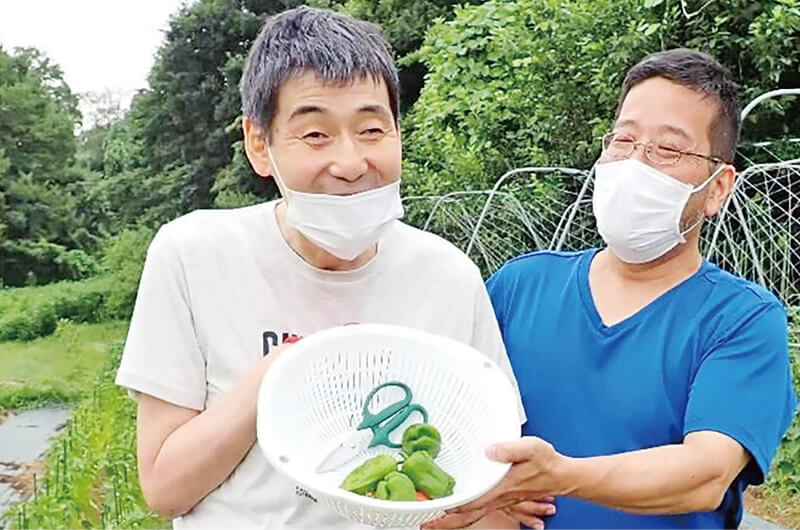 畑で収穫物を手にする男性