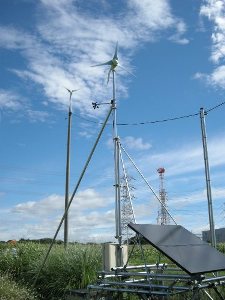 図1 太陽光風力発電装置(手前)と電柱の上に設置風力発電装置(奥)