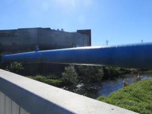 脇に水道管のような大きな管が通っている橋