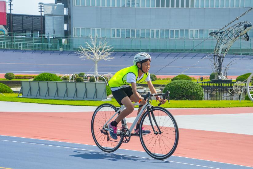 自転車を必死にこいでいる姿の斜め前からの写真