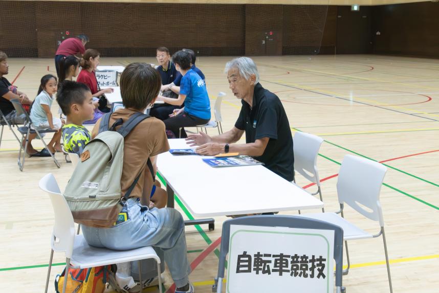 個別相談ブースにて参加児童、保護者が競技団体と話している画像