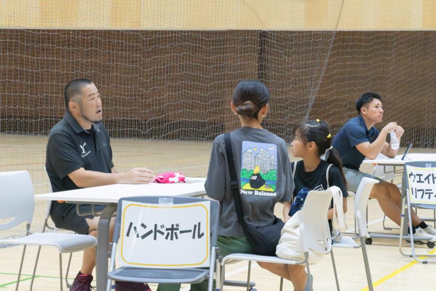 個別相談ブースにて参加児童、保護者が競技団体と話している画像