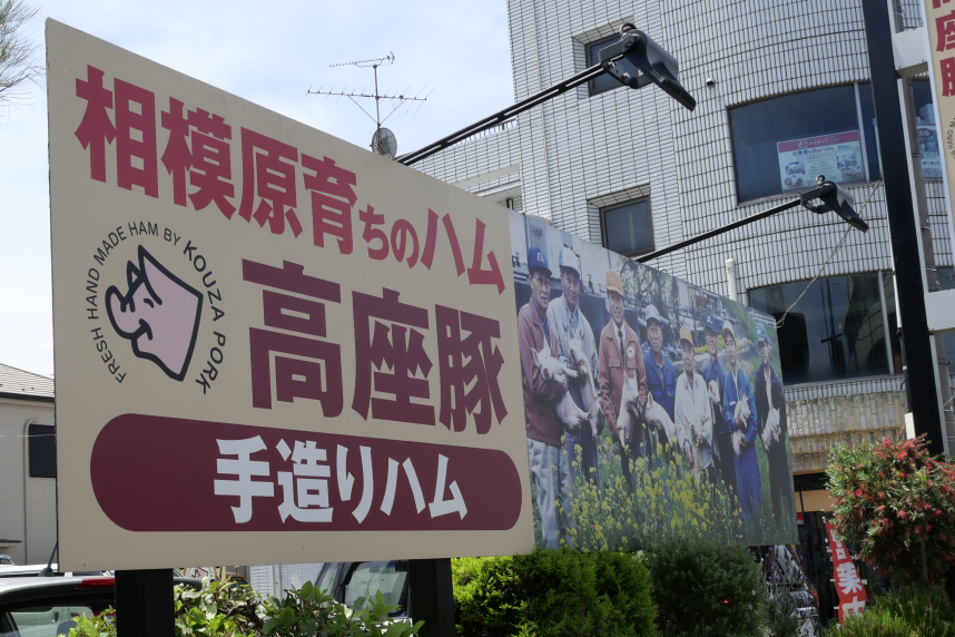 駐車場にある高座豚手造りハムの看板写真