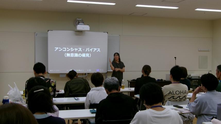 受講者に講師が講義している写真