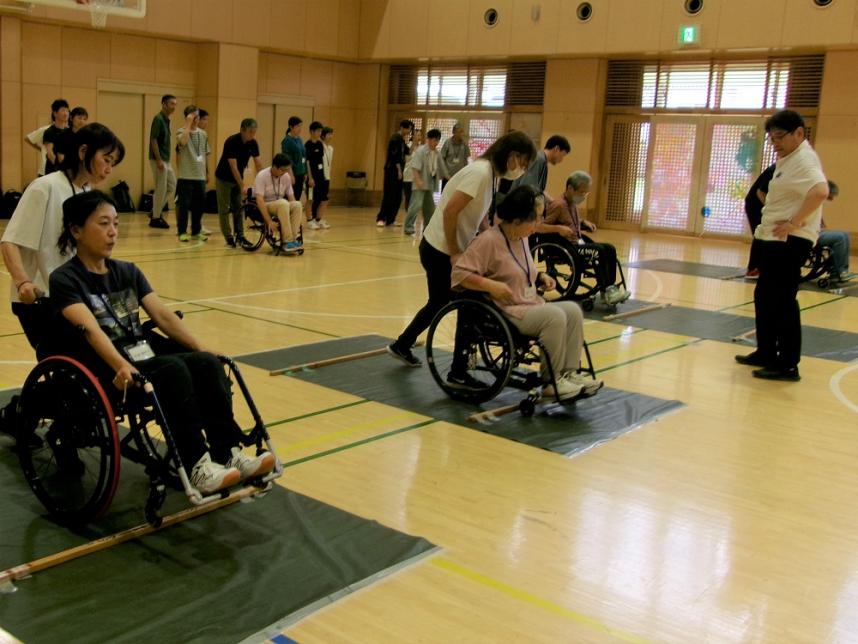 受講者が福祉用車いすに乗車し、他の受講者がそれを押している写真
