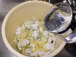 写真：塩水を回しかけながら漬け込み容器に入れる