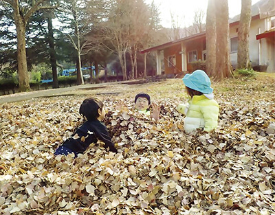 落ち葉で遊ぶ子どもたち