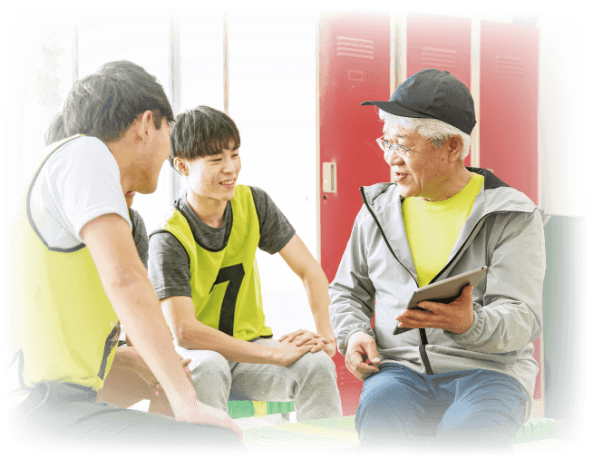 タブレットを一緒に操作しながら会話をするシニア男性と若年男性