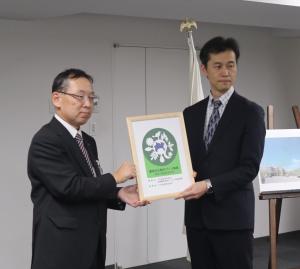認証マークを持っての記念撮影