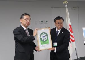 認証マークを持っての記念写真